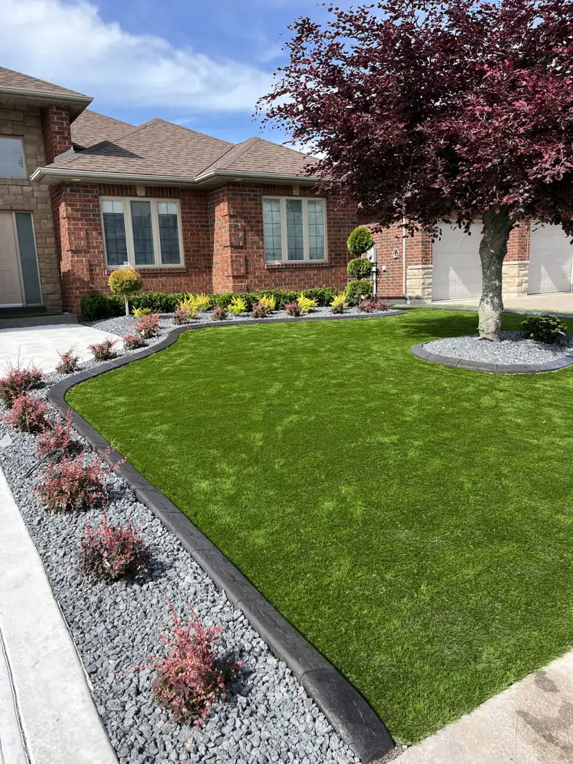 After: artificial turf, black curbing and stone beds