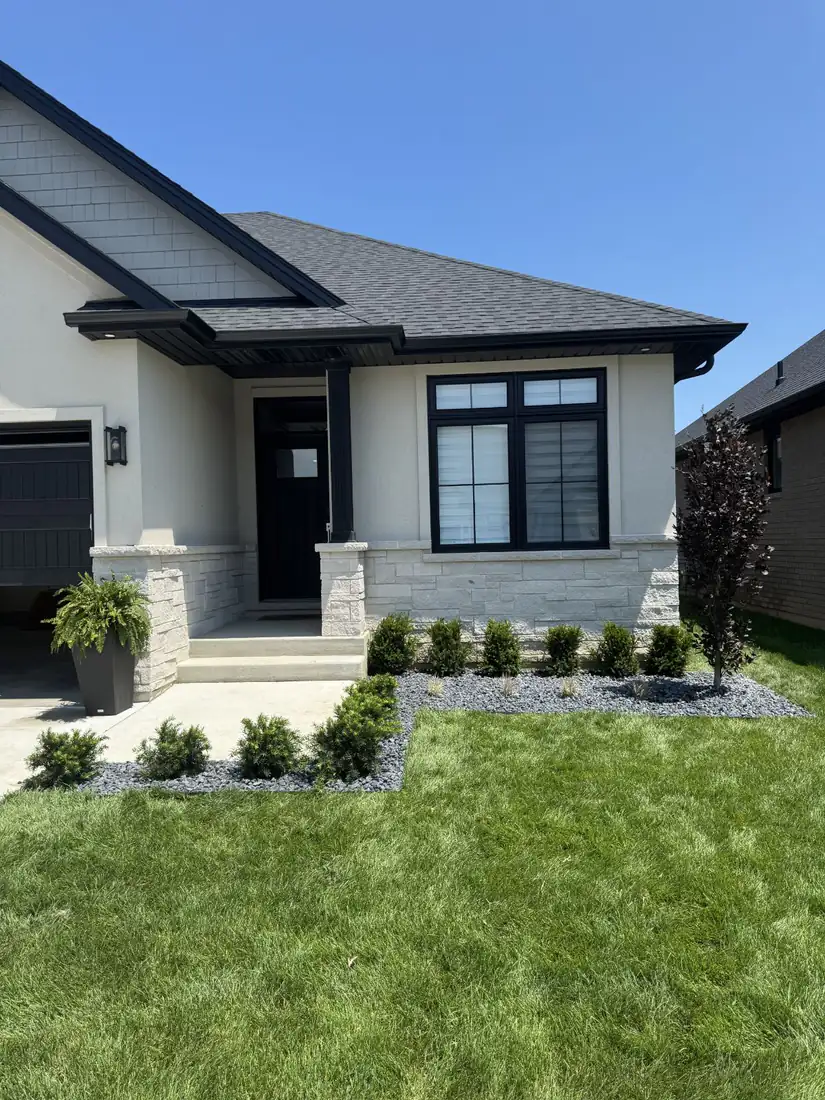 After: new garden bed with black stone and shrubs