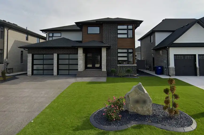 Boulder address stone in a black stone bed with curbing
