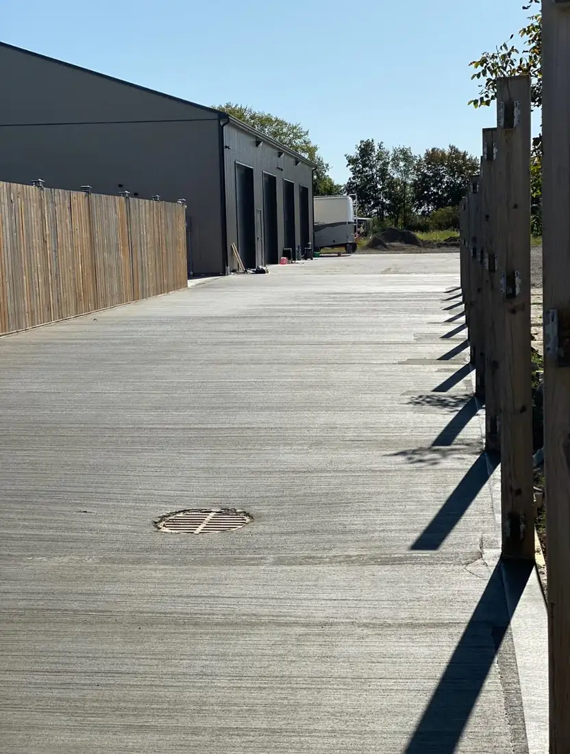 Concrete laneway beside a wood fence