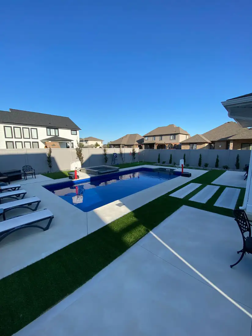 Concrete pool deck with turf strips