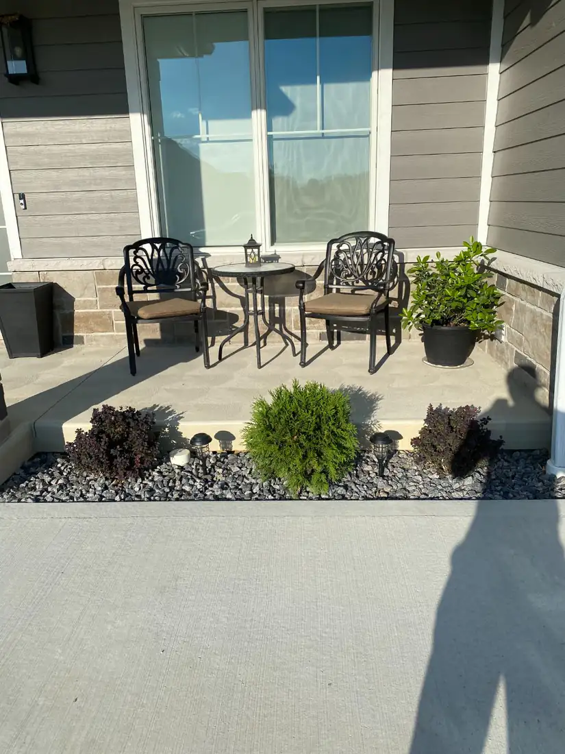 Shrubs in a stone bed by the porch