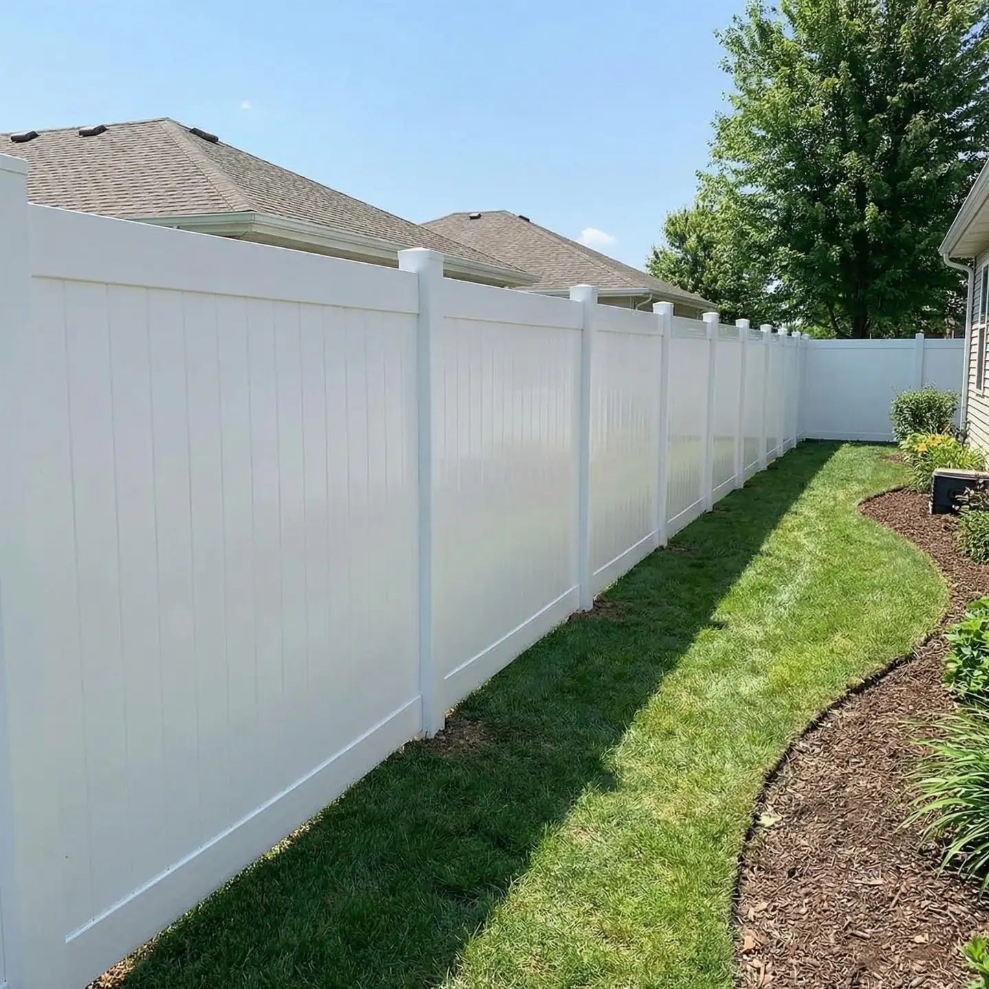 White vinyl fence along a graded lawn and bed